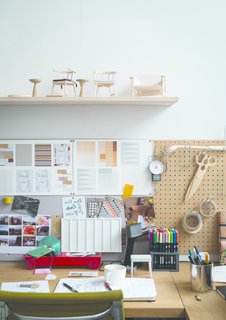 Meet the London Furniture Designers Working in a Reclaimed Railway Shed - Photo 7 of 11 - A shelf of models sits over a design station layered with inspiration. 
