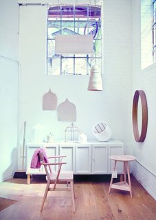 Meet the London Furniture Designers Working in a Reclaimed Railway Shed - Photo 10 of 11 - In the Pinch showroom, a Holland Park School armchair designed by Richard Pinch for Ercol sits beside a Clyde lamp table and Frey sideboard from the Pinch collection. The brand's Iona mirror hangs on the wall while their gauzy Beata pendant dangles from above. 