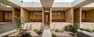 The materials—concrete, stone, and brick—reference the local architecture, tying the house to its site and making it easier to find a construction team.