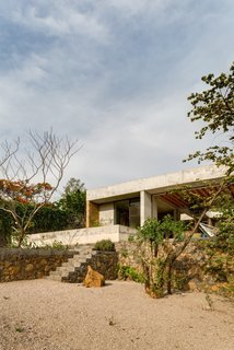 The concrete-and-brick house is perched on a stone wall. 