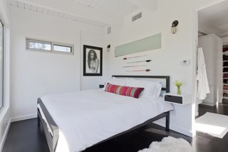 Graphic Design Inspired This Handcrafted Canyon Hideaway - Photo 6 of 10 - The couple's minimalist bedroom was imagined like a suite in a boutique hotel. There is a bedroom, closet, and bathroom, but minimal furniture as to avoid cluttering the bright white space. 