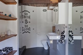 Graphic Design Inspired This Handcrafted Canyon Hideaway - Photo 9 of 10 - Chad looked to his experience in graphic design when creating his family's home. Elements of text and graphics can be found throughout, including the inlaid tiles that spell out "So Fresh & So Clean" in the guesthouse bathroom.