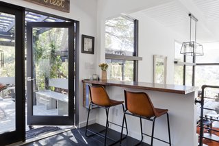 Graphic Design Inspired This Handcrafted Canyon Hideaway - Photo 5 of 10 - Reorganizing the kitchen and dining area was a key point of the renovation. Now it's an open space that links to the deck, which the family uses as an outdoor living space. 