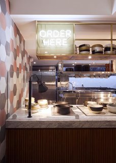 The custom shelving at Dig Inn’s new Boston location is upcycled antique brass. 