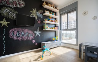 A Riotous Makeover for a Generic High-Rise Home - Photo 3 of 3 - A chalkboard wall encourages creative exploration in the child’s room. 