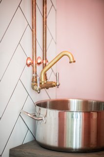Find Fresh Foods in an Even Fresher Locale in Montreal - Photo 2 of 2 - Rustic brass fixtures are attached to a wall of subway tile that has been arranged in a herringbone pattern.