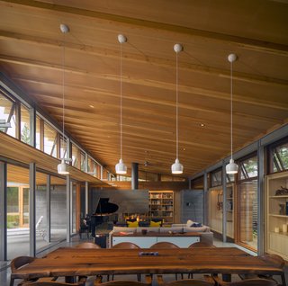 Channeling Midcentury Modern in Northern California - Photo 1 of 7 - Honest materials appear throughout this Los Altos, California, home. In the double-height living area, Mantis chairs by BassamFellows surround a custom live-edge dining table, fashioned from an old Claro walnut tree with help from Menlo Hardwoods. 