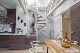 This Modern Boston Renovation Expertly Mixes in Colorful Craft Finds - Photo 1 of 4 - When Alan Ricks and Cristina de la Cierva moved into their Boston condo, a ship’s ladder was taking up space in the main living area. Following a lengthy renovation, a spiral staircase provides rooftop access. 