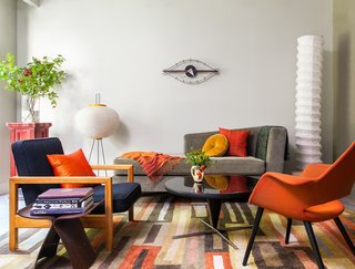 The living room includes two Noguchi lights, an Organic chair by Charles Eames and Eero Saarinen for Vitra, and a Nelson Eye clock. 