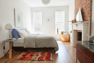 The furnishings reflect an eclectic mix of old and new. In a second-floor guest room, a bedside table by Fort Standard holds a vintage lamp. The artwork above the bed is by Evan Venegas. 