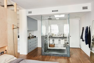 One of the boldest moves was the glass-encased shower inside the revamped master bedroom. "Obviously, building that shower was not a cost-saving option," says Keith, "but we used green slate, which is not super expensive, either." The Architec sinks are from Duravit.