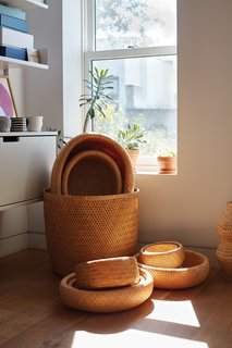 A Vitsoe shelving system and a collection of bamboo baskets made in Vietnam occupy a sunny corner in the office that Lauren and Keith share on the top floor. 