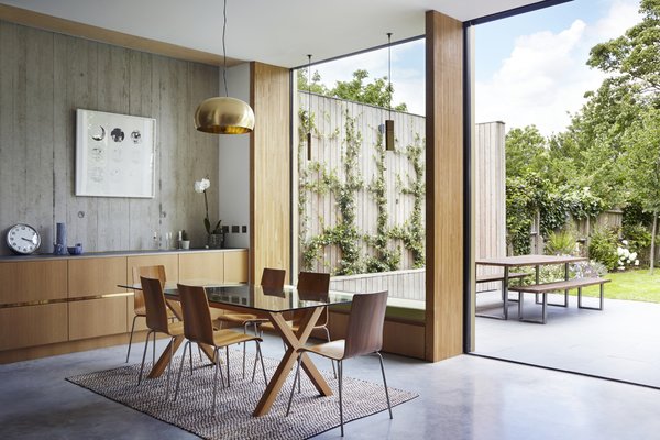 This Modern Courtyard Home Celebrates a 100-Year-Old Tree - Photo 6 of 8 - The dining room table is from Habitat. The oak veneered plywood is by Peter Benson Plywood. 