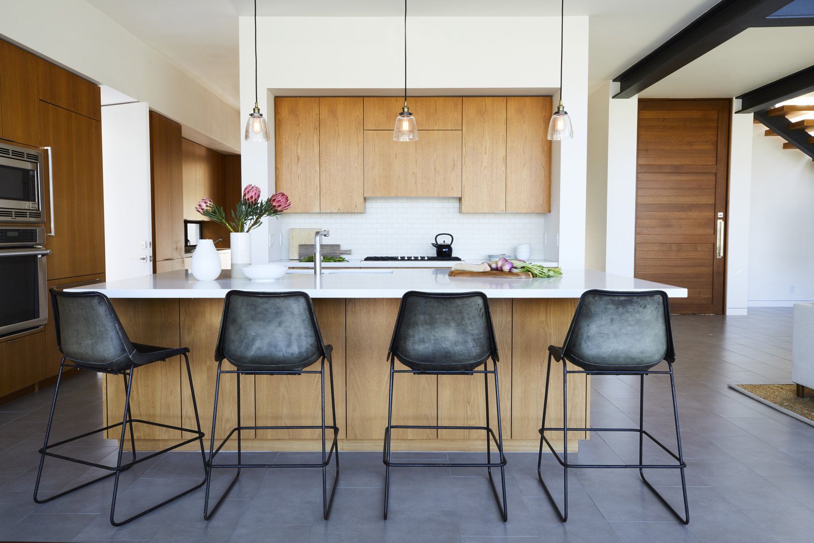 The industrial bar stools in the minimalist kitchen were purchased at ABC Home.