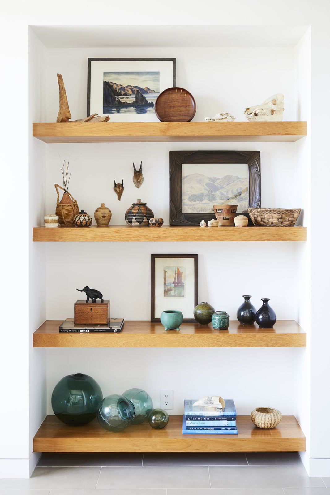 Teak shelves were used in the entryway to display the owners' art collection and souvenirs from abroad.