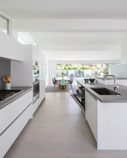 A Breezy Midcentury Renovation in the Hollywood Hills - Photo 1 of 2 - The panel ready dishwasher, with functional third rack, is tucked seamlessly into the kitchen island.