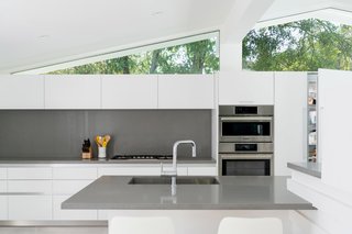 A Breezy Midcentury Renovation in the Hollywood Hills - Photo 2 of 2 - The sleek oven duo, aligned beautifully with clerestories above, sits flush with kitchen cabinetry.