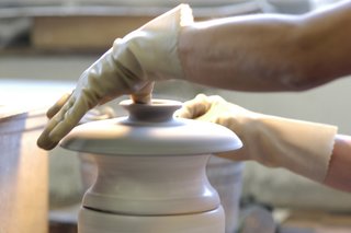 Sausalito Dinnerware Factory Tour - Photo 16 of 35 - Many details require an addition step. Here, a lid is pulled off the wet clay when it is being formed. This handle is for a casserole lid. There is no mold for this piece, so each finished lid has its own character.