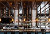 Modern home with Dining Room, Bar, and Pendant Lighting. Seven Pod pendants in Amber glass hang above the bar. The linear grouping of Pod pendants from individual junction boxes adds length to the bar top, creating visual depth in the interior. The honey-colored hue of our luxurious Amber glass brings warmth to the atmosphere, complementing the dark wood tones and producing an inviting environment for guests to enjoy. Photo of Oak Steakhouse - Charlotte