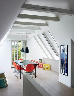 10 Bright and Airy Modern Attic Renovations - Photo 1 of 10 - A cramped attic was transformed into a sunny dining room with Vitral windows and white-tinted pine floors by Dinesen. The Sara table is by Hay, the Shell chairs are by Charles and Ray Eames, and the artwork is a hand-printed textile which has been framed.