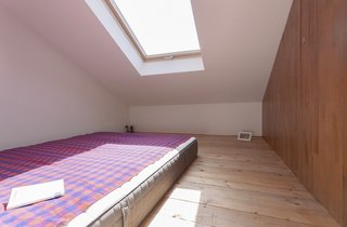 10 Bright and Airy Modern Attic Renovations - Photo 5 of 10 - The ladder from the kitchen leads to this "sleeping box," a tucked-away room perfect for guests. The addition of a skylight brightens the space. 
