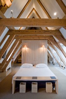 10 Bright and Airy Modern Attic Renovations - Photo 7 of 10 - Giant wooden roof beams in the attic suite add to the peaceful and minimalist space.