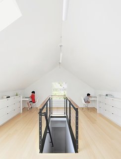 10 Bright and Airy Modern Attic Renovations - Photo 10 of 10 - Bamboo flooring and custom built-ins—fashioned from medium-density fiberboard with a white-lacquer finish—brightened the 650-square-foot attic. The custom-designed blackened-steel balustrade has cable inserts and a walnut handrail.