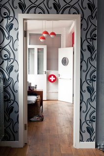 9 Inspirational Examples of Adaptive Reuse - Photo 1 of 9 - View into the bedroom with private terrace from the living room. A simple palette of grays blends with the industrial-chic aesthetic, with splashes of red and gold.