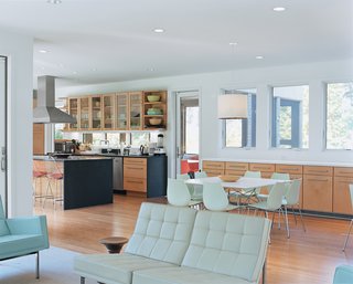 The living room is furnished with Modernica’s Split Rail loveseat and sofa and a walnut Eames stool from Herman Miller. The dining area features Vico Magistretti’s Maui chairs and an Antonio Citterio Glossy table, both from plastics expert Kartell.