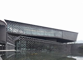 Architect Spotlight: 12 Works by Japanese Architect Kengo Kuma - Photo 2 of 12 - Locally-made tiles that are fixed tightly with stainless-steel wires create a curtain that covers the facade. 