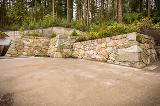 Take a Tour of Kengo Kuma’s Expansion of the Portland Japanese Garden - Photo 4 of 8 - A 15th-generation stone mason was brought from Japan to construct the expansion's 185-foot-long, 18.5-foot-high "castle wall." The Baker Blue granite stones sourced from Baker City, Oregon, were handpicked and hand-laid with a seismically-safe traditional technique. Interestingly, the artisan was very excited about this project as he had never actually built a new wall—in Japan, his work consists of repairing ancient structures.