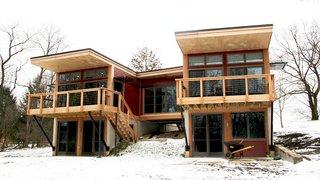 Located on a picturesque country lane in Pittsburgh, the modules of this 1,240-square-foot prefab from Method Homes are connected by a suspended glass-filled bridge.