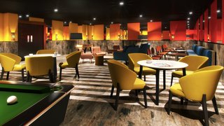 "Again, our goal was to accent the warm, welcoming feeling that's typical of Collegiate AC residences. We used warm metal tones like copper and brass, soft furnishings, and rugs." - Design Command. Pictured is the Game Room.