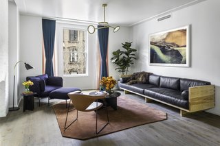 Formerly Home to Superman, The Standish Offers Modernized Beaux-Arts Condos From $1.3 Million - Photo 2 of 8 - A large custom-made leather sofa from Wherewithal defines the living room, making it a comfortable space for entertaining. The Cloud One Seater lounge chair by Luca Nichetto and a Bellevue Floor Lamp by Arne Jacobsen form a perfect reading spot near the window, offering views of Brooklyn's neighboring brownstones. 