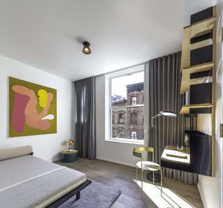 Formerly Home to Superman, The Standish Offers Modernized Beaux-Arts Condos From $1.3 Million - Photo 5 of 8 - The second bedroom boasts Matter Made’s mounted desk with shelving units designed by Henry Julier, paired with a brass Avoa chair designed by Pedro Paulø-Venzon—also from Matter Made. A Vonnegut Kraft Crescent Lounge daybed completes the space.
