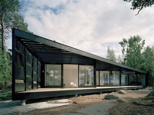 A Look at 10 Minimalist Scandinavian Cabins - Photo 5 of 10 - A light-weight building in glass and wood, this summer house in the Stockholm archipelago has been inspired by its location. A dark wood exterior, strong vertical presence, and abundance of windows help integrate the residence into its surrounding environment. <span style="color: rgb(204, 204, 204); font-size: 13px;">Tham & Videgard Hansson Arkitekter</span>