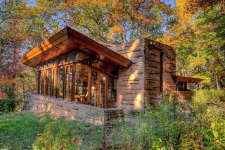 10 Frank Lloyd Wright Homes Available to Rent Right Now - Photo 1 of 10 - This tiny house set on the bucolic Mirror Lake in Wisconsin is balanced on the edge of a steep hill and measures only 880 square feet. The "flying roof" seems to hang in space without support. Wright was already in his 90s when Seth Peterson asked him to design the cottage, and the 1958 building was Wright’s last Wisconsin project. Wright died in April 1959, before construction was completed. 