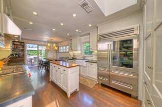 On the Market For $4.5M, This Venice Beach Compound Captures the Essence of Indoor-Outdoor Living - Photo 3 of 8 - The interiors of the 3,200-square-foot main house have been decked out with attention to high-quality construction and first-rate architectural details. The open cook's kitchen features a built-in dining area and breezy outdoor access. 