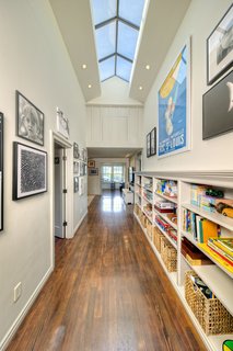 On the Market For $4.5M, This Venice Beach Compound Captures the Essence of Indoor-Outdoor Living - Photo 6 of 8 - Upstairs, there are three bedrooms, customized and spacious closets, a children's bathroom, a family room, and a craft and music room overlooking the yard. The high-ceilinged hallway is brightened by natural light via a skylight which extends over the length of the passage. 