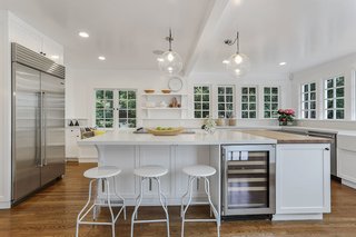 With an Architectural Pedigree and Green Certification, This Pasadena Home Just Listed For $3.6M - Photo 1 of 10 - The bright and spacious kitchen is full of windows which blend indoors and outdoors. The updated space, which merges historic architecture with modern features, showcases a butler's pantry, breakfast alcove, and deck access for outdoor dining.