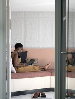 Take a Peek Inside Airbnb's New Loft-Inspired Office Space in Paris - Photo 12 of 13 - The "espace zen" is a peaceful space created for employees to have a peaceful area for quiet reflection or a quick nap. The space features a built-in sofa with plush pillows and a private balcony. 