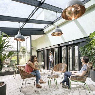 Take a Peek Inside Airbnb's New Loft-Inspired Office Space in Paris - Photo 1 of 13 - Stepping out of the elevator on the sixth floor, visitors are transported into a luminous, vegetation-filled solarium. 