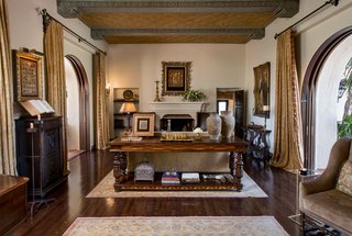 Just Listed at $4M, This Spanish Colonial Revival in Southern California Promises Resort-Like Living - Photo 2 of 8 - The main house showcases a great room with original gold-leaf ceiling panels and arched mahogany pocket doors, opening the entire home to the gardens and fountains.