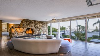 Experience L.A. Like an A-Lister at One of These Modern Short-Term Rentals - Photo 5 of 11 - The large, open floor plan creates a free-flowing connection between the living, dining, and entertaining spaces. A massive natural rock fireplace holds court in the living area. 