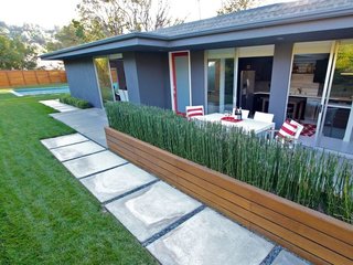 Experience L.A. Like an A-Lister at One of These Modern Short-Term Rentals - Photo 11 of 11 - Although L.A. isn't a walking city, this midcentury home is actually walking distance from coffee shops and restaurants. The contemporary interiors of the home feature an open-plan design with sliding doors for privacy. The property also has a private gated yard and a spectacular outdoor space that's complete with a saltwater pool and hot tub. 