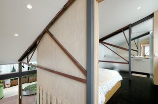 A 1960s Melbourne Warehouse Is Upcycled and Transformed Into an Energy-Efficient Family Home - Photo 5 of 11 - New bedrooms and en suite bathrooms are nestled into the roof volume between the existing<br>trusses by way of plywood-clad pods.