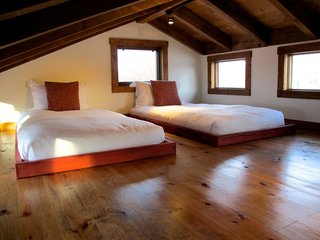 Test Out Tiny House Living at One of These Nature-Immersed Cabin Resorts - Photo 4 of 14 - A lofted bedroom with a pair of simple, low beds