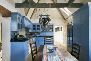 Historic Gasworks Cottage With a Modern Cor-Ten Steel Addition Hits the Market - Photo 5 of 9 - The kitchen is located in the old stone gasworks and features a vaulted ceiling and bespoke, painted cabinets.