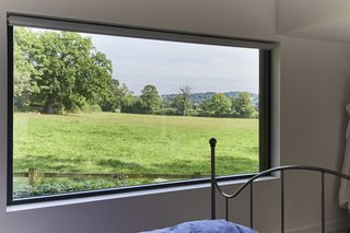 Historic Gasworks Cottage With a Modern Cor-Ten Steel Addition Hits the Market - Photo 7 of 9 - The master bedroom suite boasts a large picture window with far-reaching rural views.