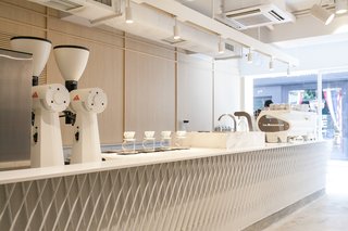 A Sleek Coffee Shop in Hong Kong With Beautiful, Minimalist Interiors - Photo 2 of 9 - Custom-made by Studio Adjective, the 23-foot-long coffee bar is topped with a white Corian counter. 